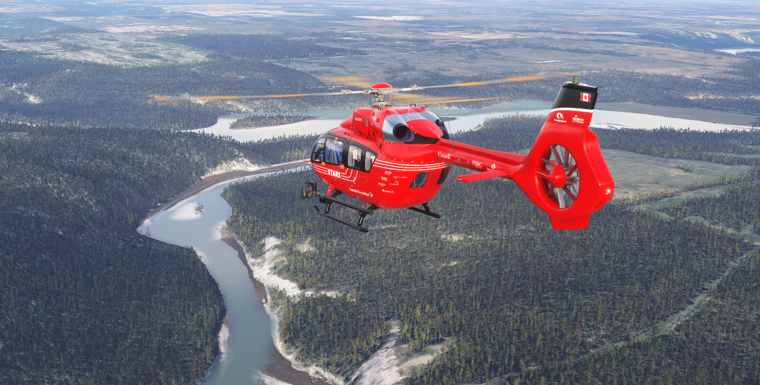 Red STARS medical helicopter (C-PSAC) in flight over forest and river