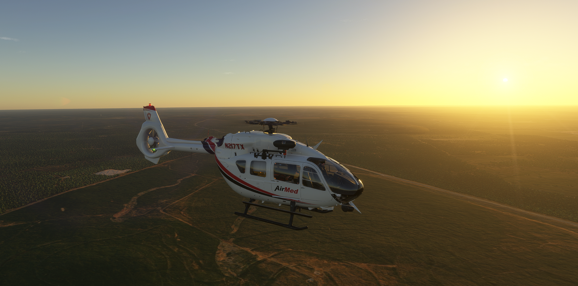 AirMed medical helicopter (N217TX) in flight over plains at sunset