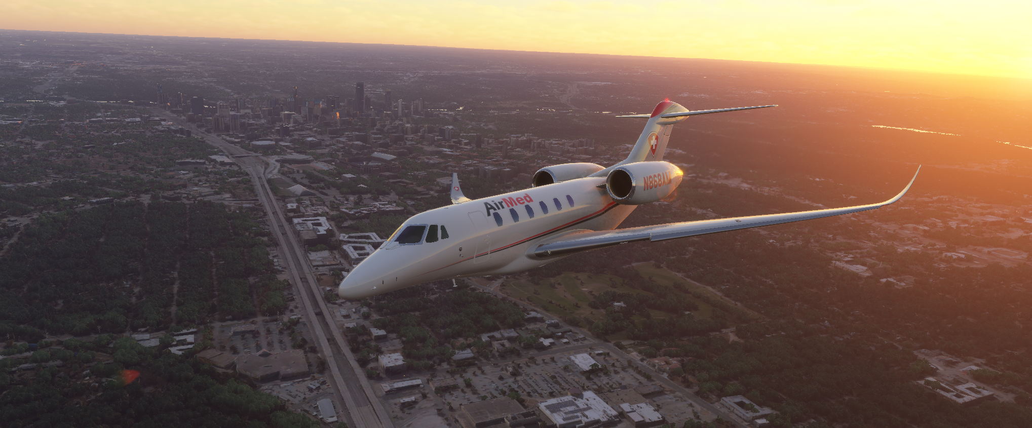 AirMed medical jet (N868AM) in flight at sunset over a city skyline