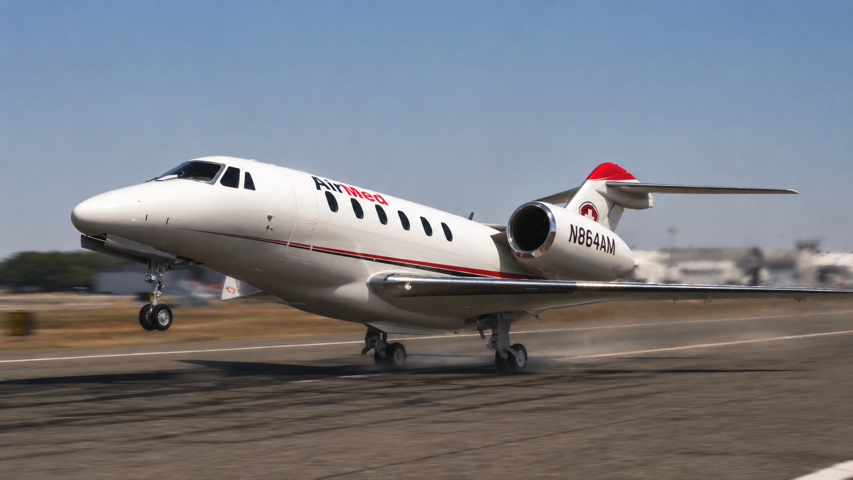 White AirMed jet (N864AM) taking off from a runway