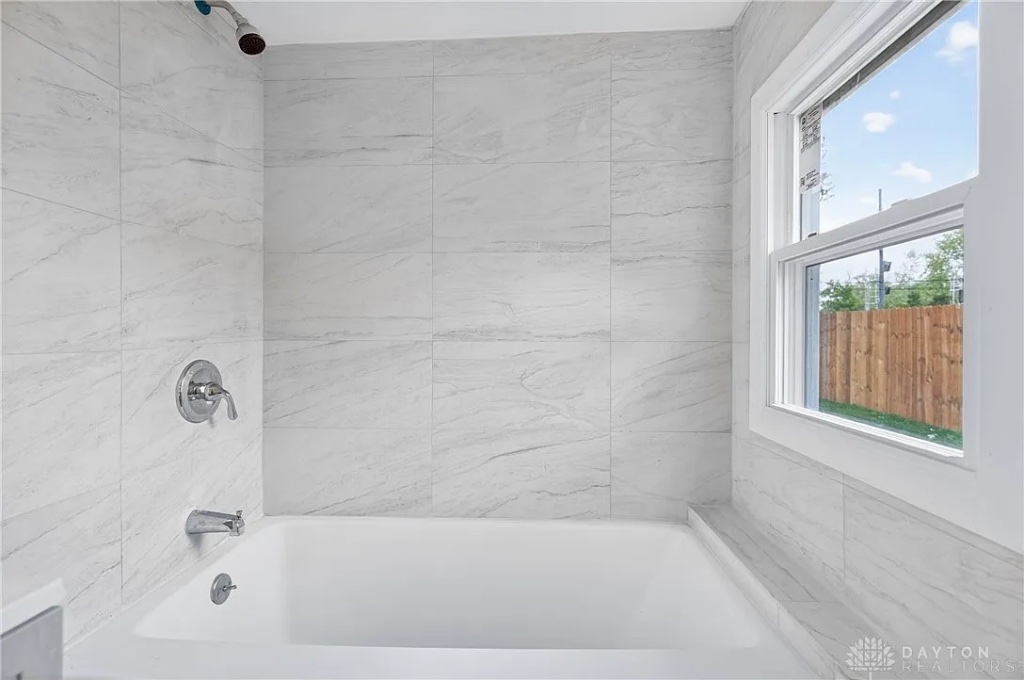 Modern Bathtub with Marble Tile Surround and Chrome Fixtures