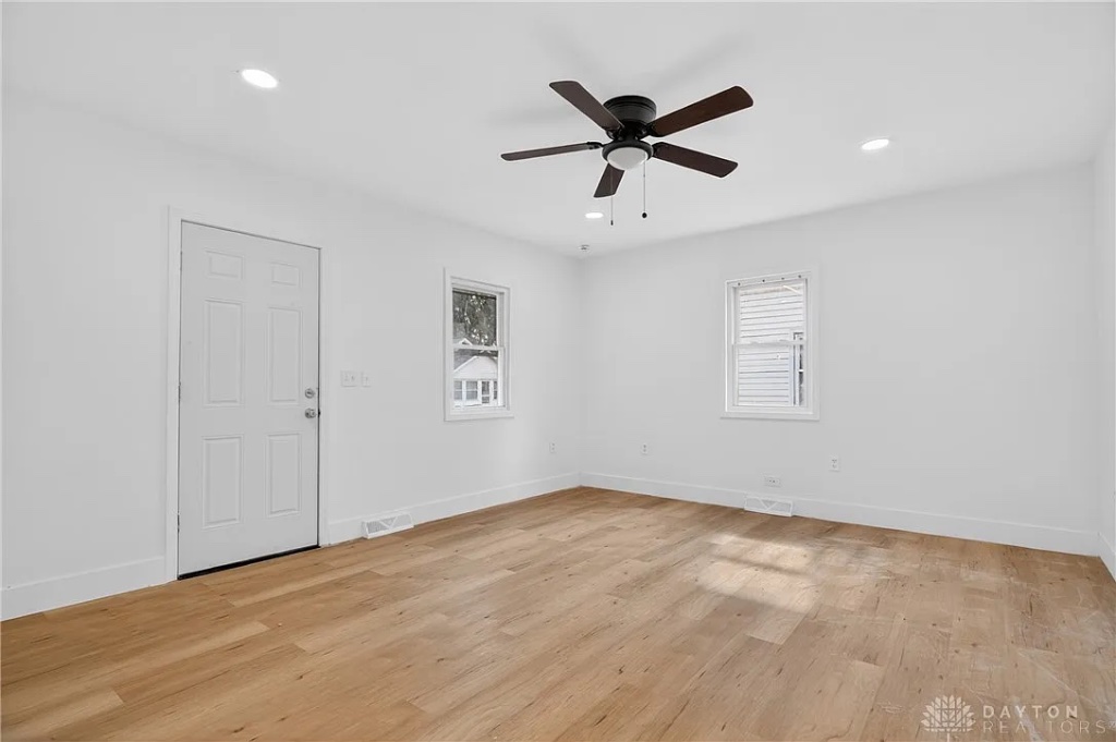 Bright Bedroom with Ceiling Fan and Fresh Laminate Flooring