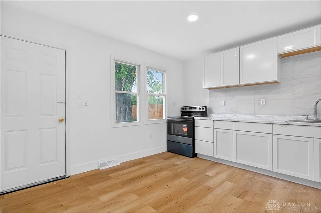 Minimalist Kitchen with Glossy White Cabinets and Marble Backsplash