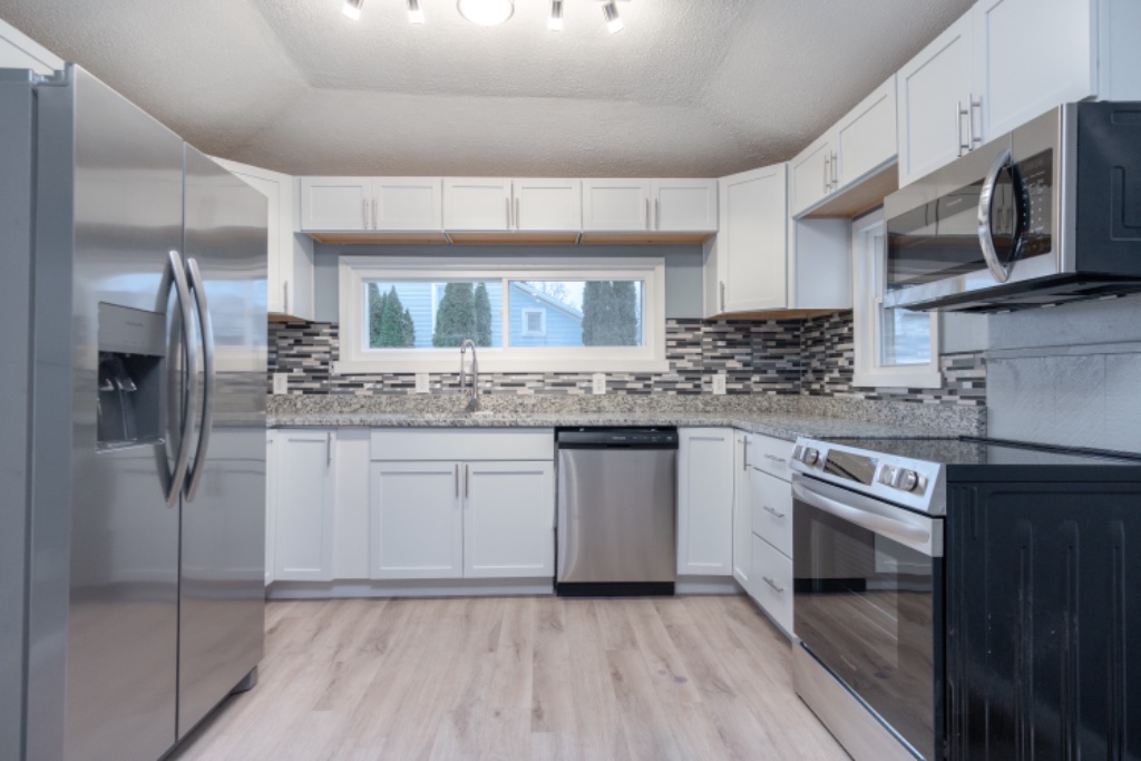 U-Shaped Kitchen with White Shaker Cabinets and Stainless Appliances