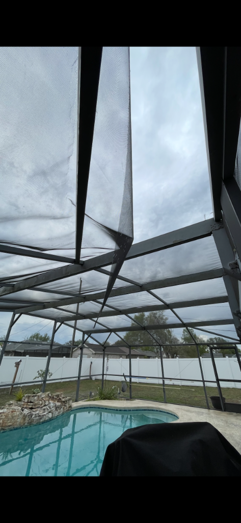 Torn and sagging pool cage roof panels showing need for full panel replacement
