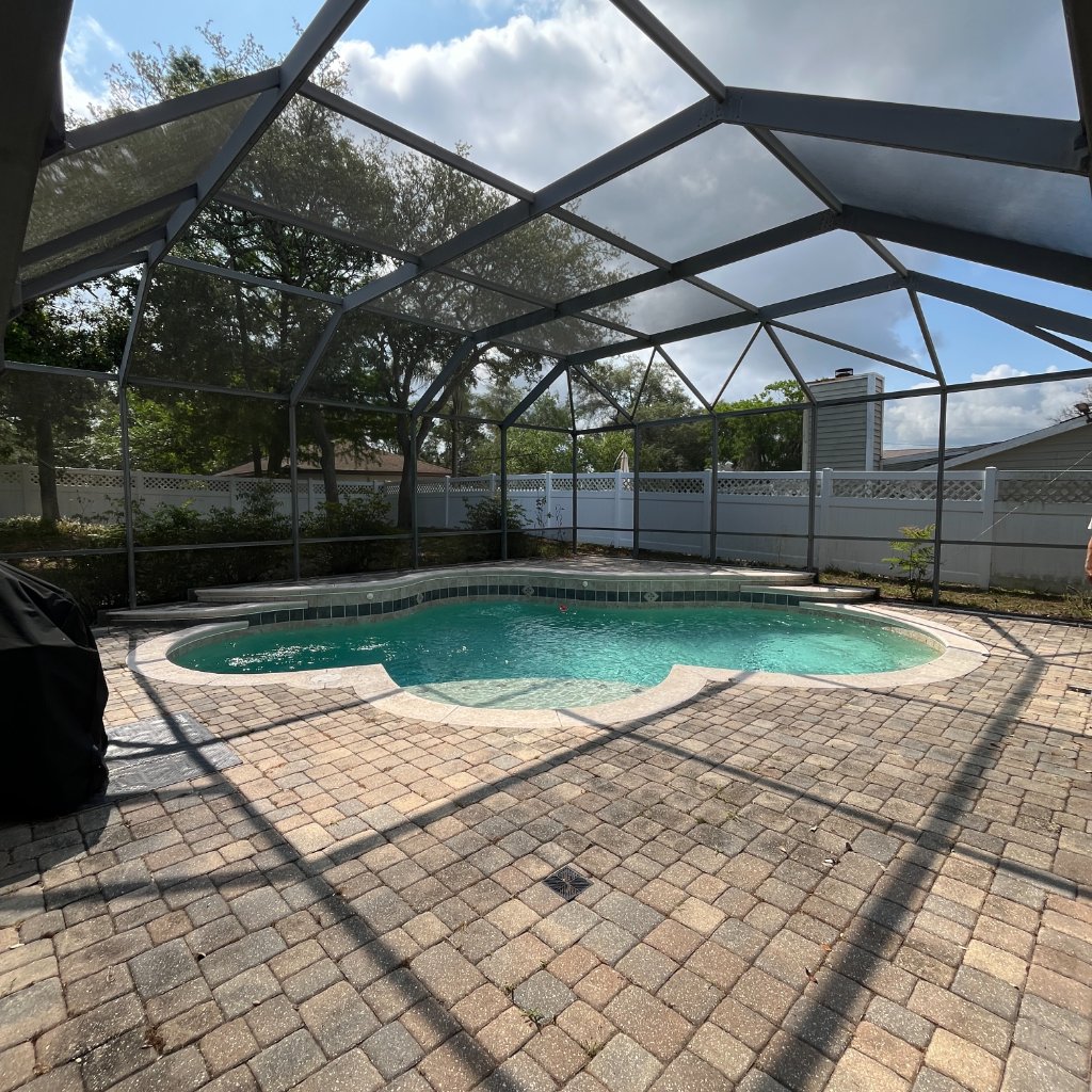 Pool cage with new screen panels and clean aluminum frames