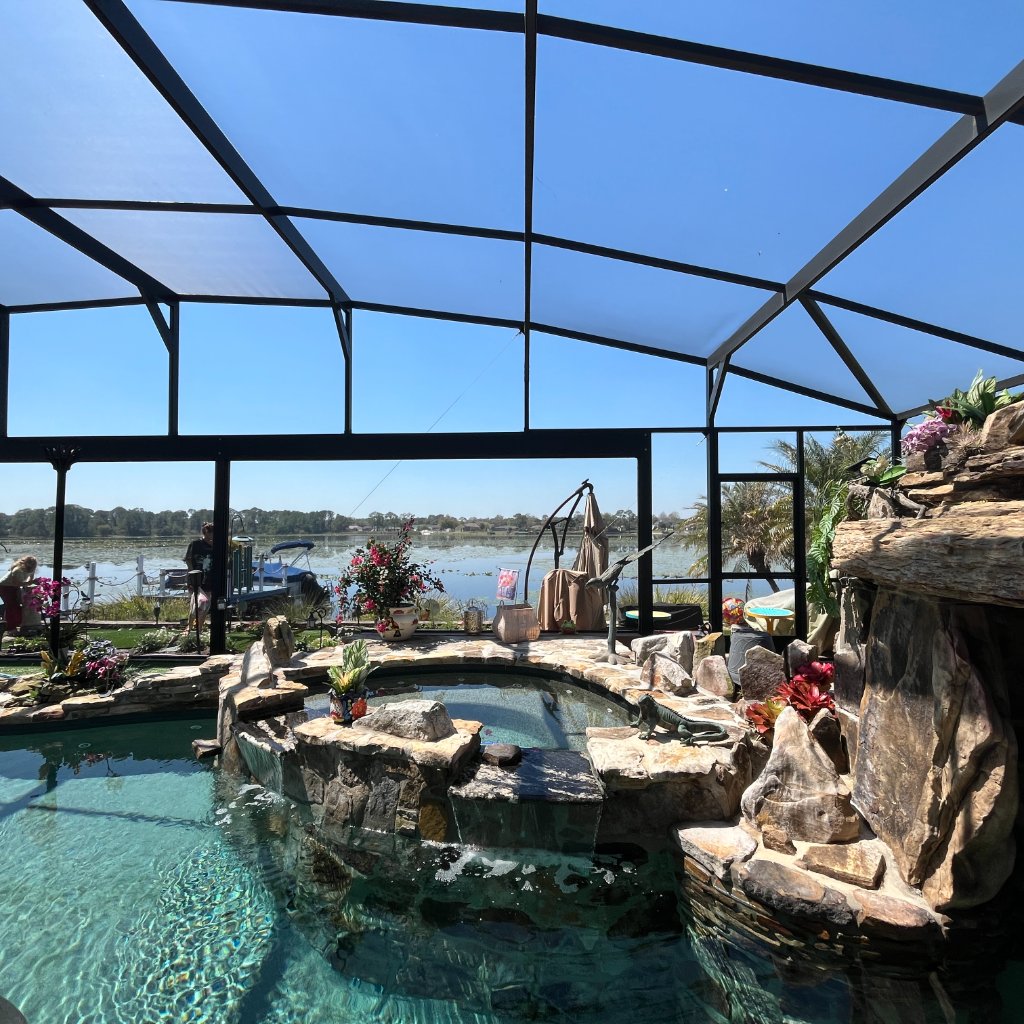 Luxury pool screen enclosure with lake view showing new screen panels