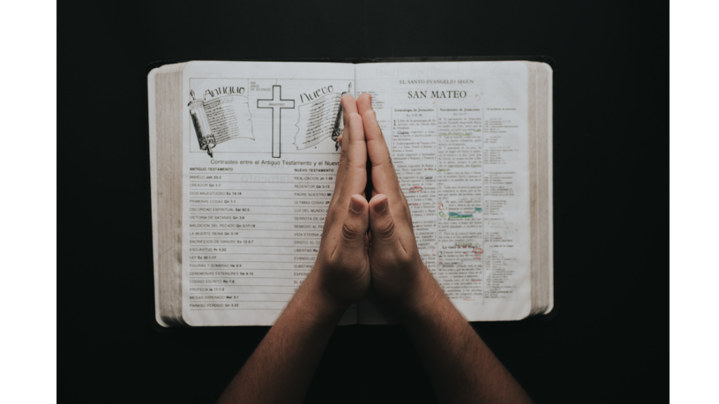 Manos en oración sobre la Biblia