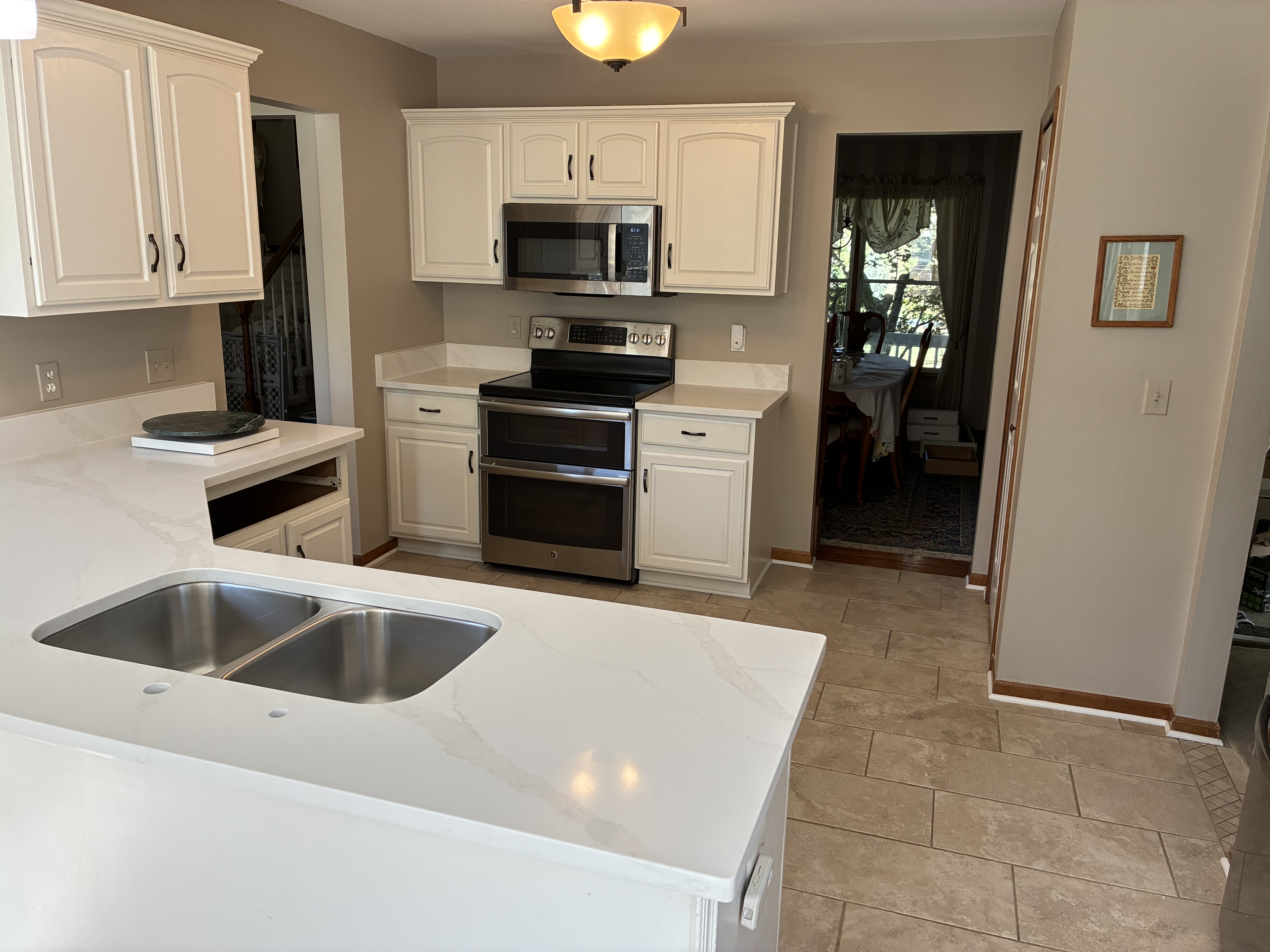 L-shaped kitchen with white quartz countertops and cream shaker cabinets