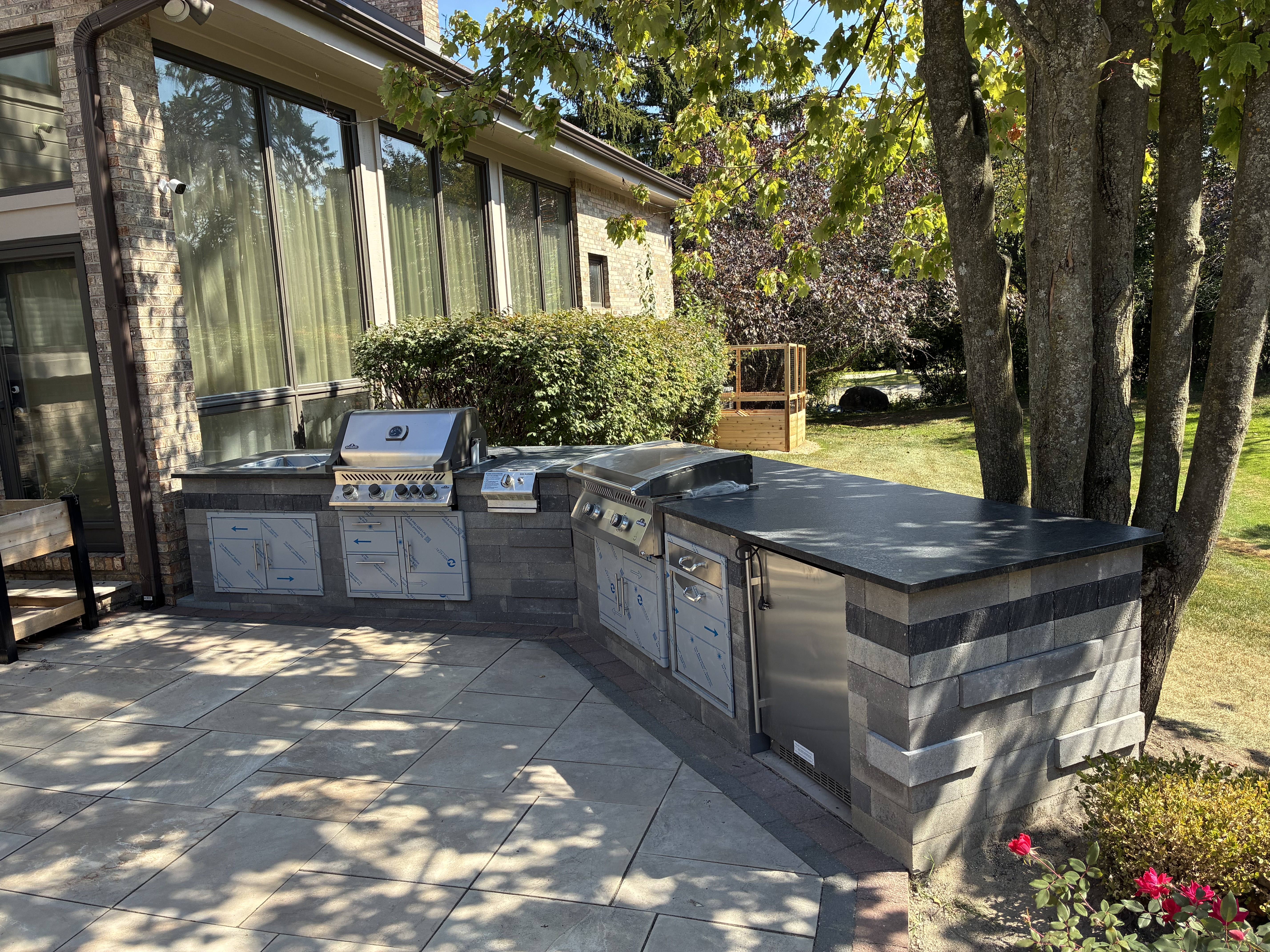 Outdoor kitchen with stone block base and dark granite countertop