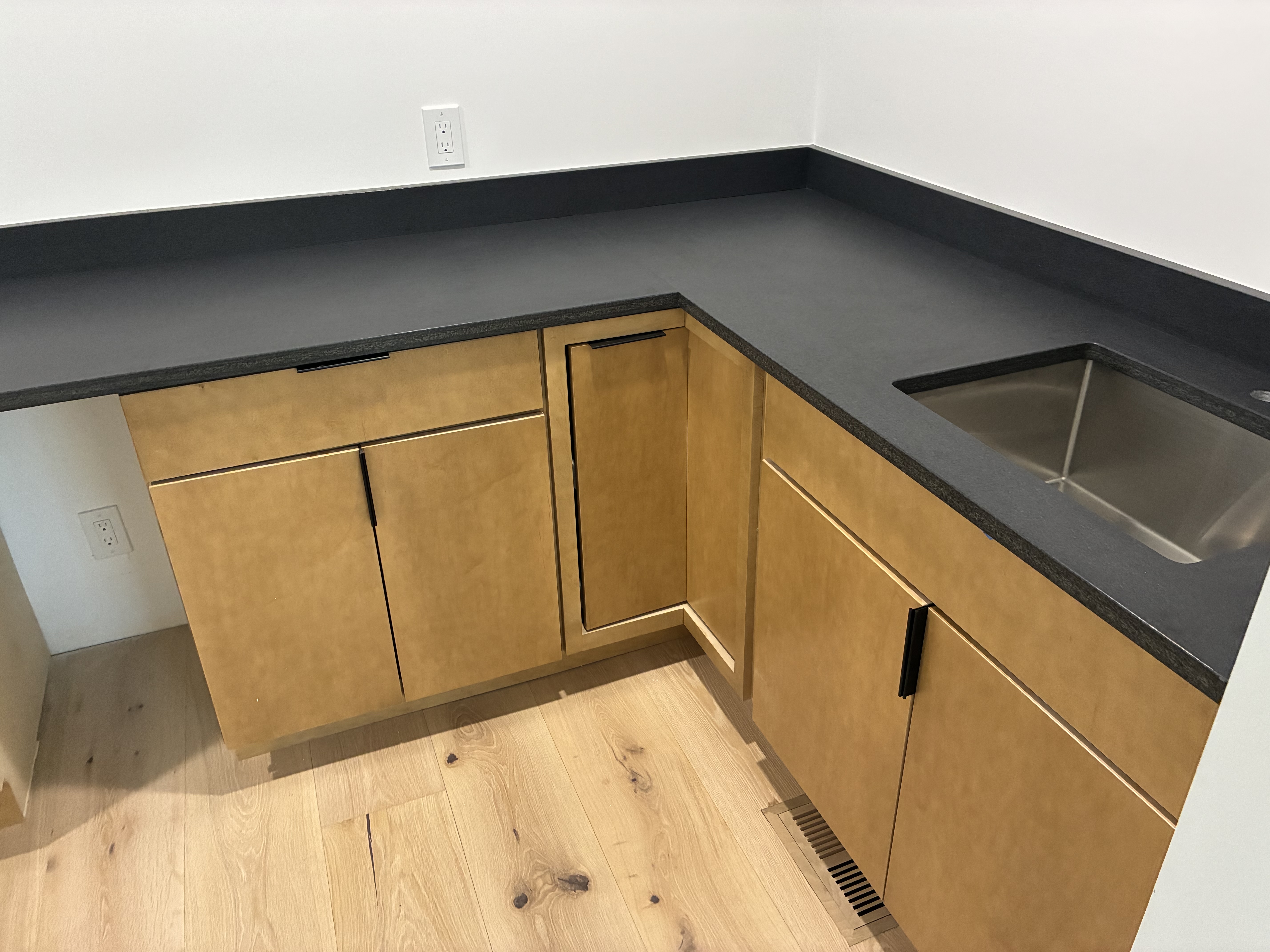 Close-up of black quartz countertop with undermount stainless steel sink
