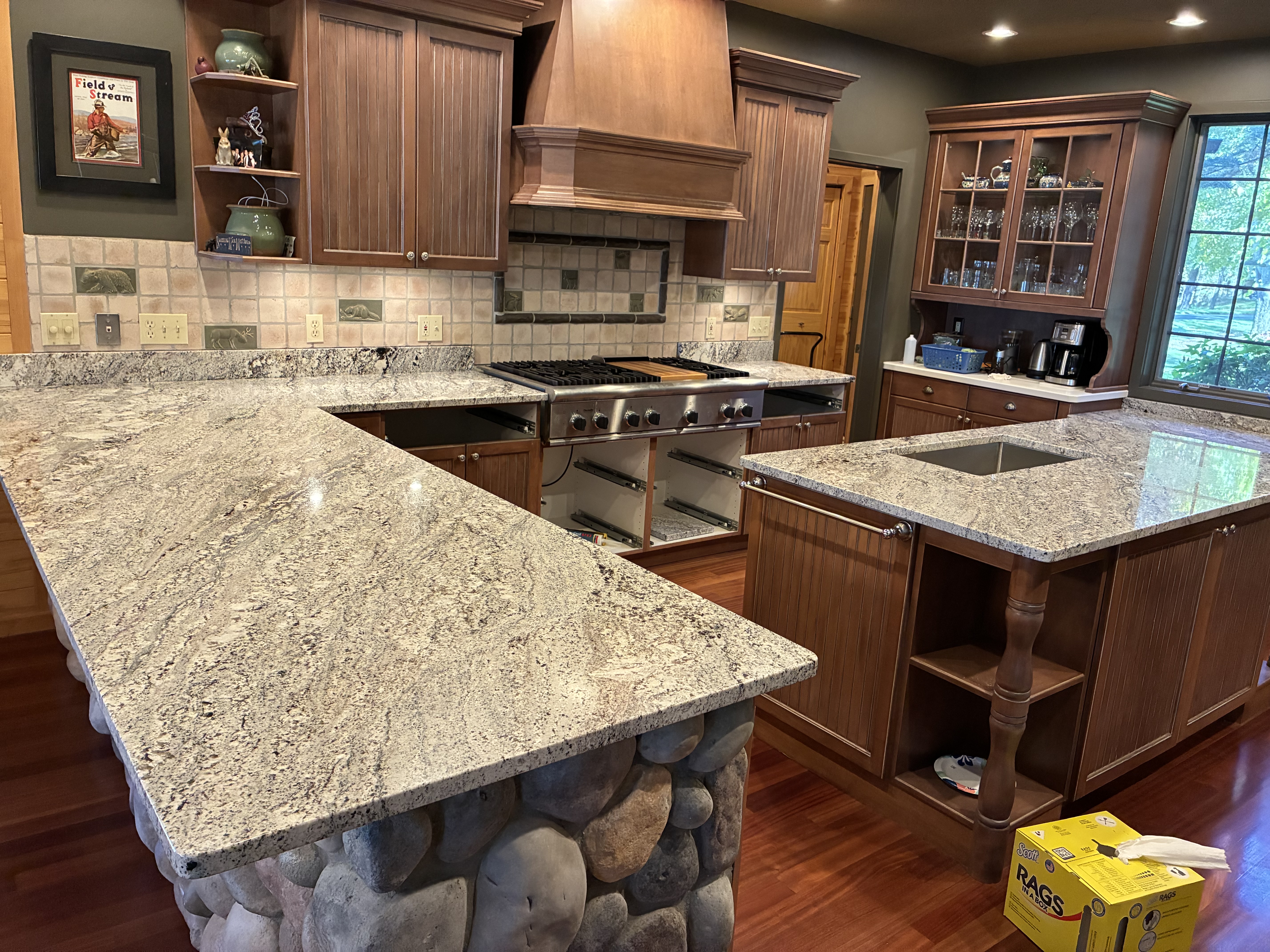 L-shaped kitchen with speckled granite countertops and decorative tile backsplash