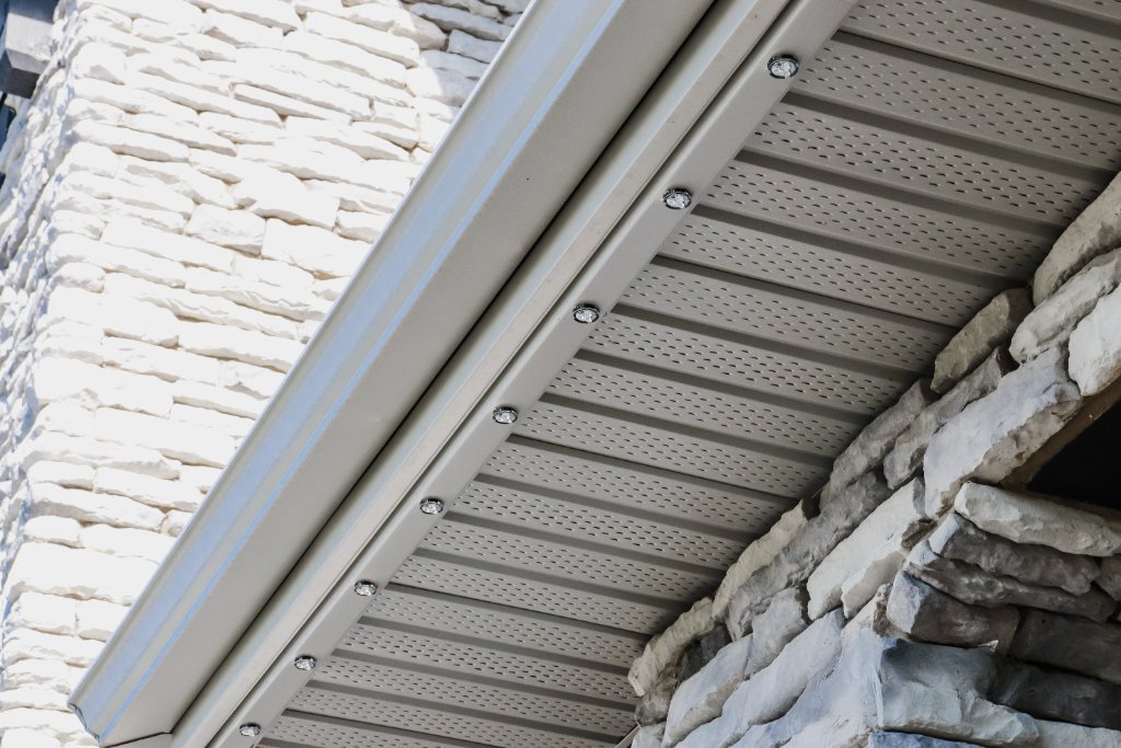Close-up of Gemstone Lights permanent track system installed in roofline soffit — daytime profile