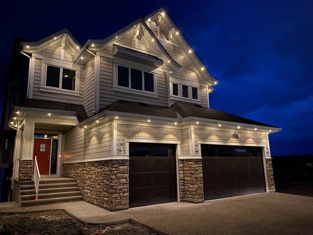Warm white Gemstone Lights architectural roofline lighting on craftsman-style home at night