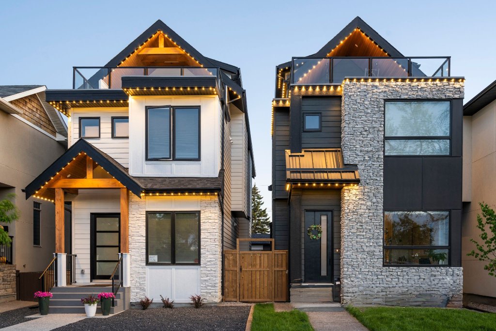 Pair of modern infill homes with warm white Gemstone Lights roofline accent lighting at dusk