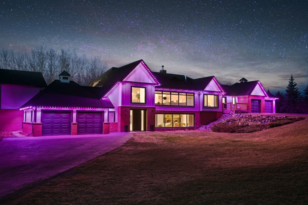 Contemporary home with bold magenta Gemstone Lights under a starry night sky