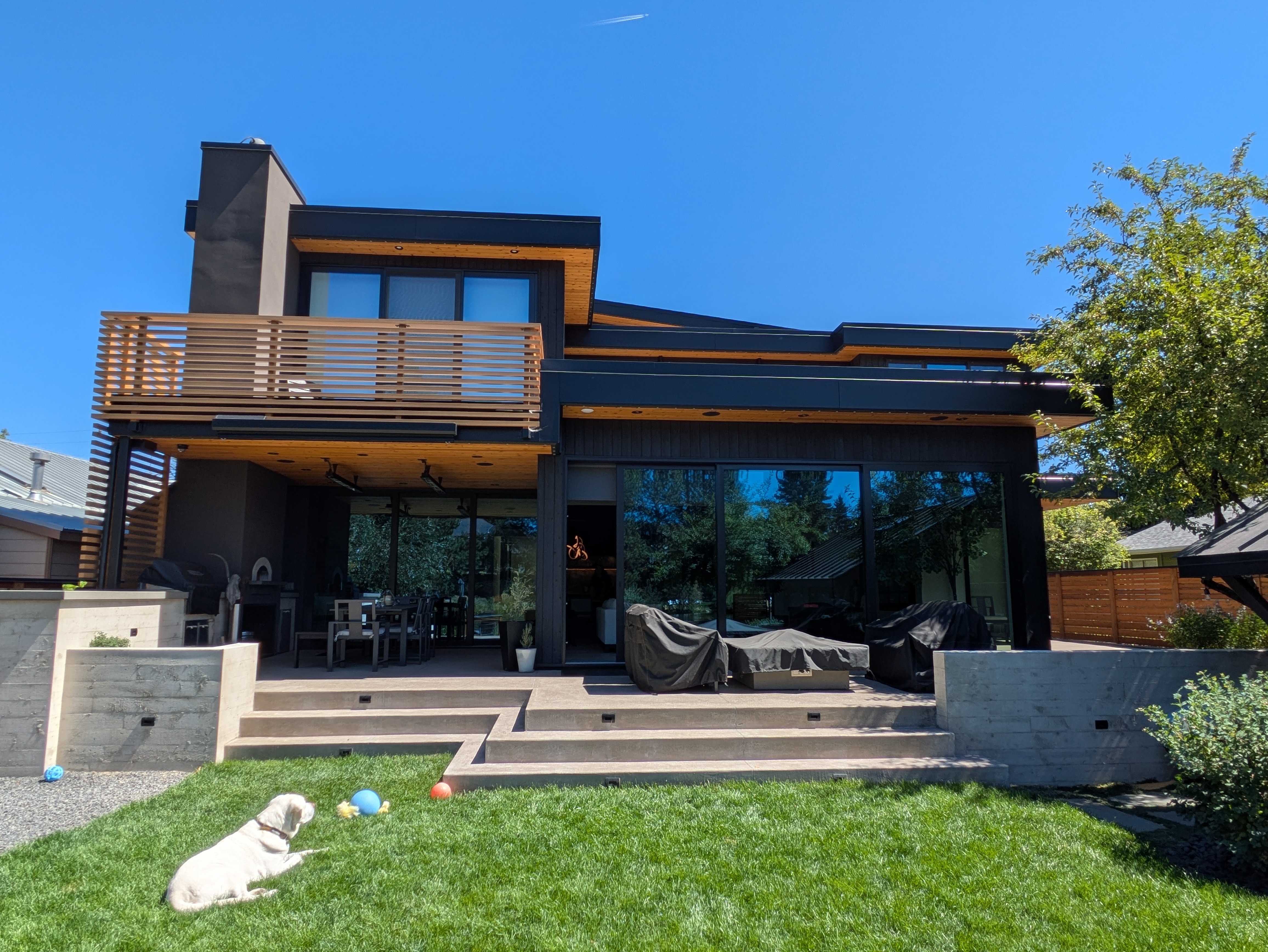 Contemporary two-story home with wood soffit and Gemstone Lights installed along the roofline in bright daylight in Bend, Oregon — daytime profile