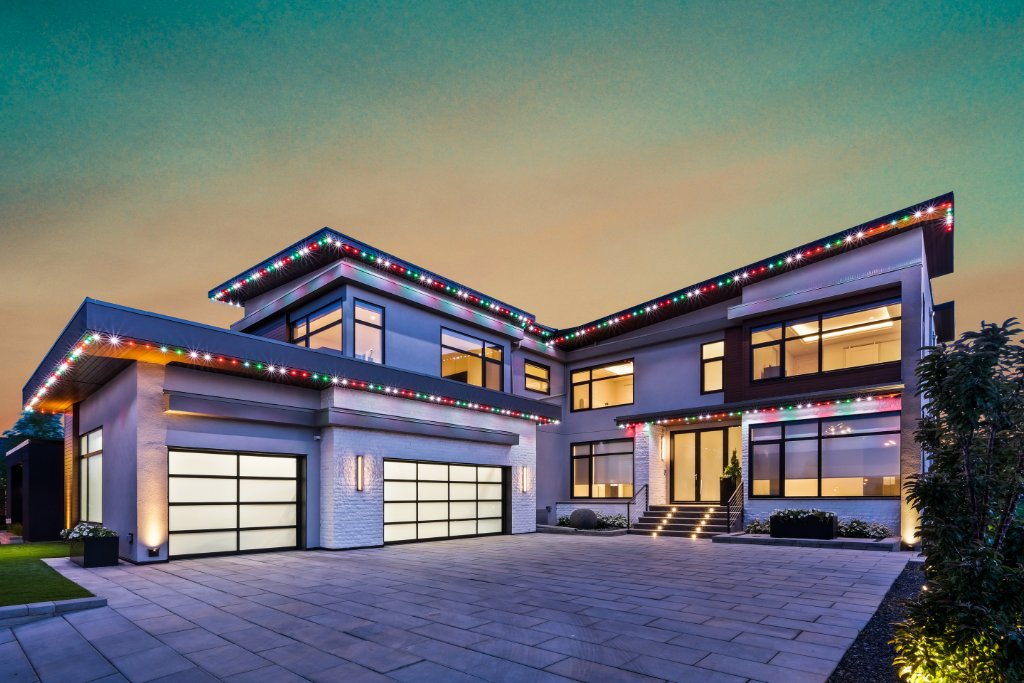 Modern luxury home with multicolor Christmas Gemstone Lights at dusk