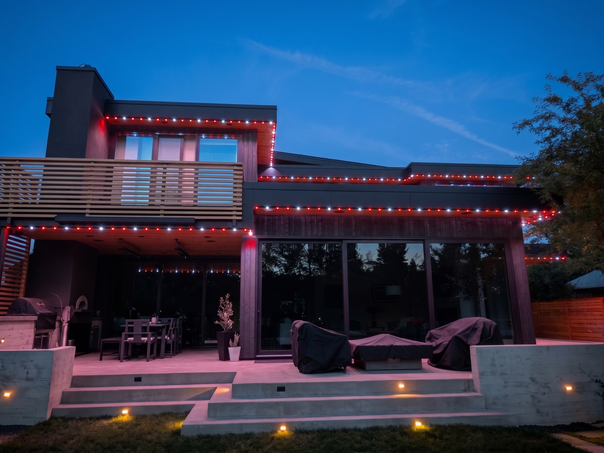 Modern multi-story home with alternating red and cool white Gemstone Lights holiday display at twilight in Bend, Oregon