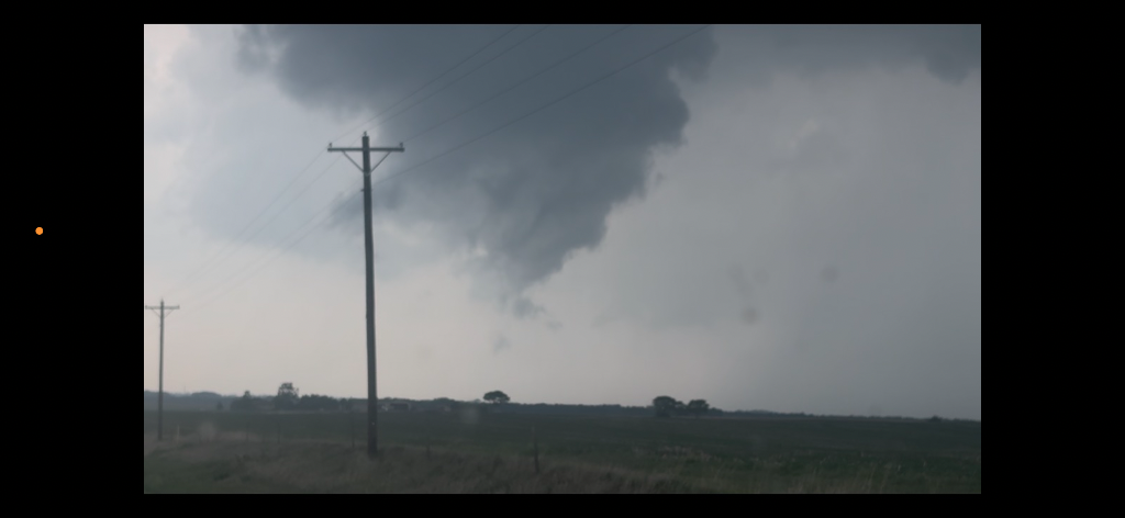 Funnel cloud forming over rural farmland