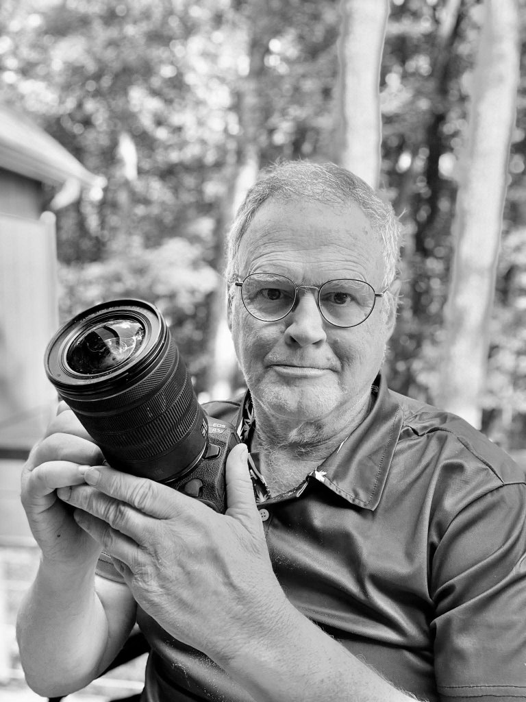 Portrait of Bill Paisley holding a Canon camera