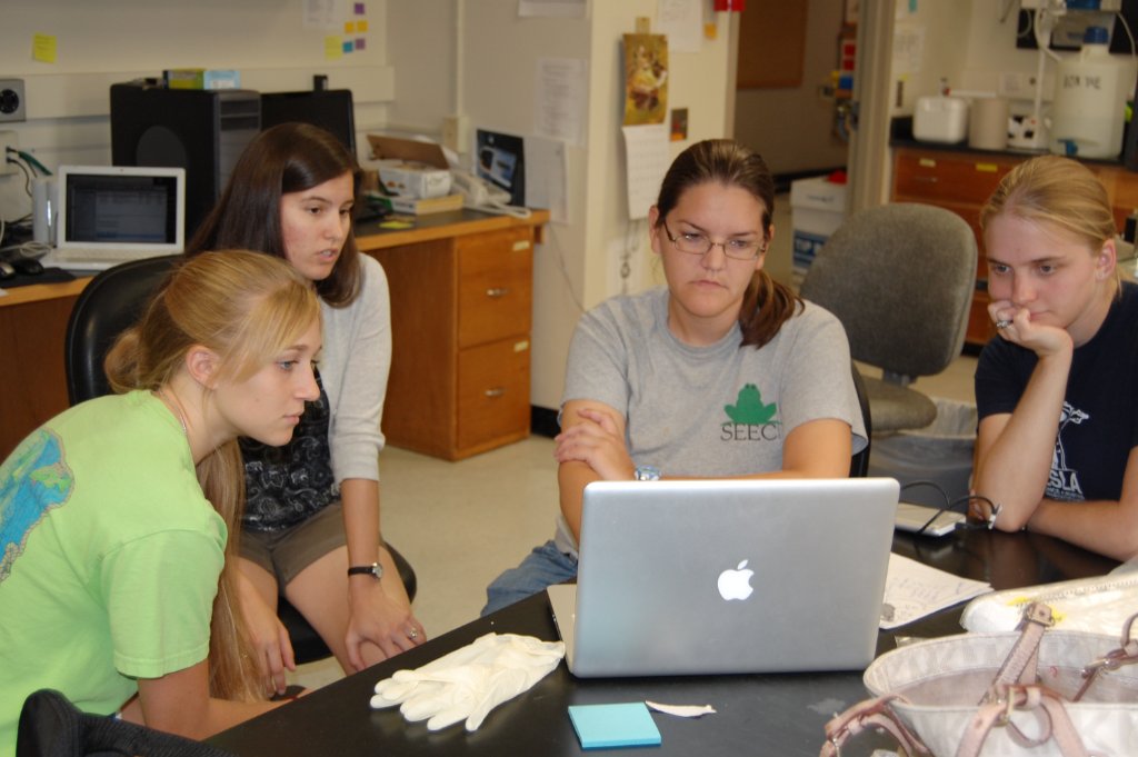 Lab members working together at a laptop