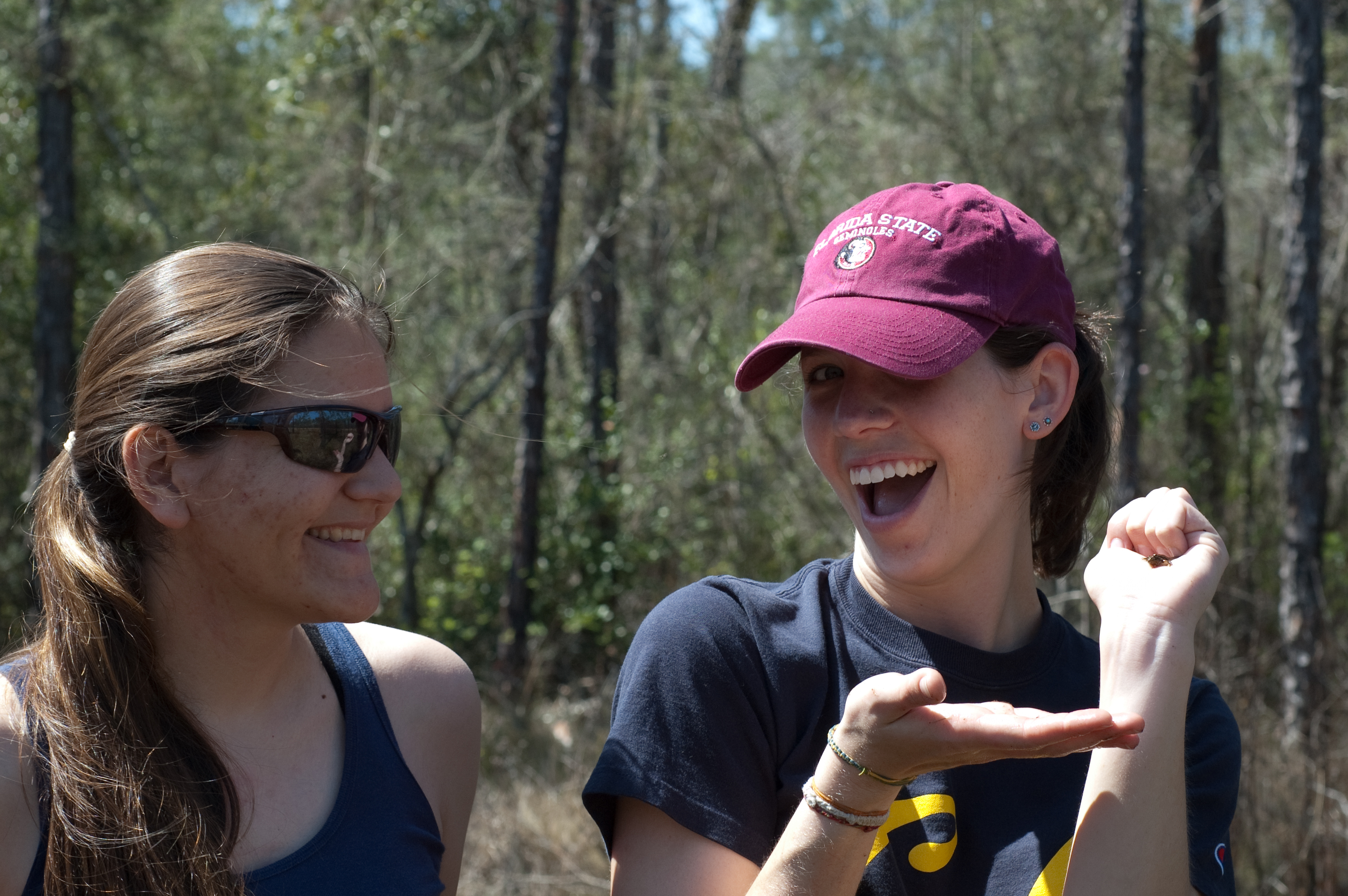 Lisa Barrow and Mallory Bedwell examining a small froglet in the field