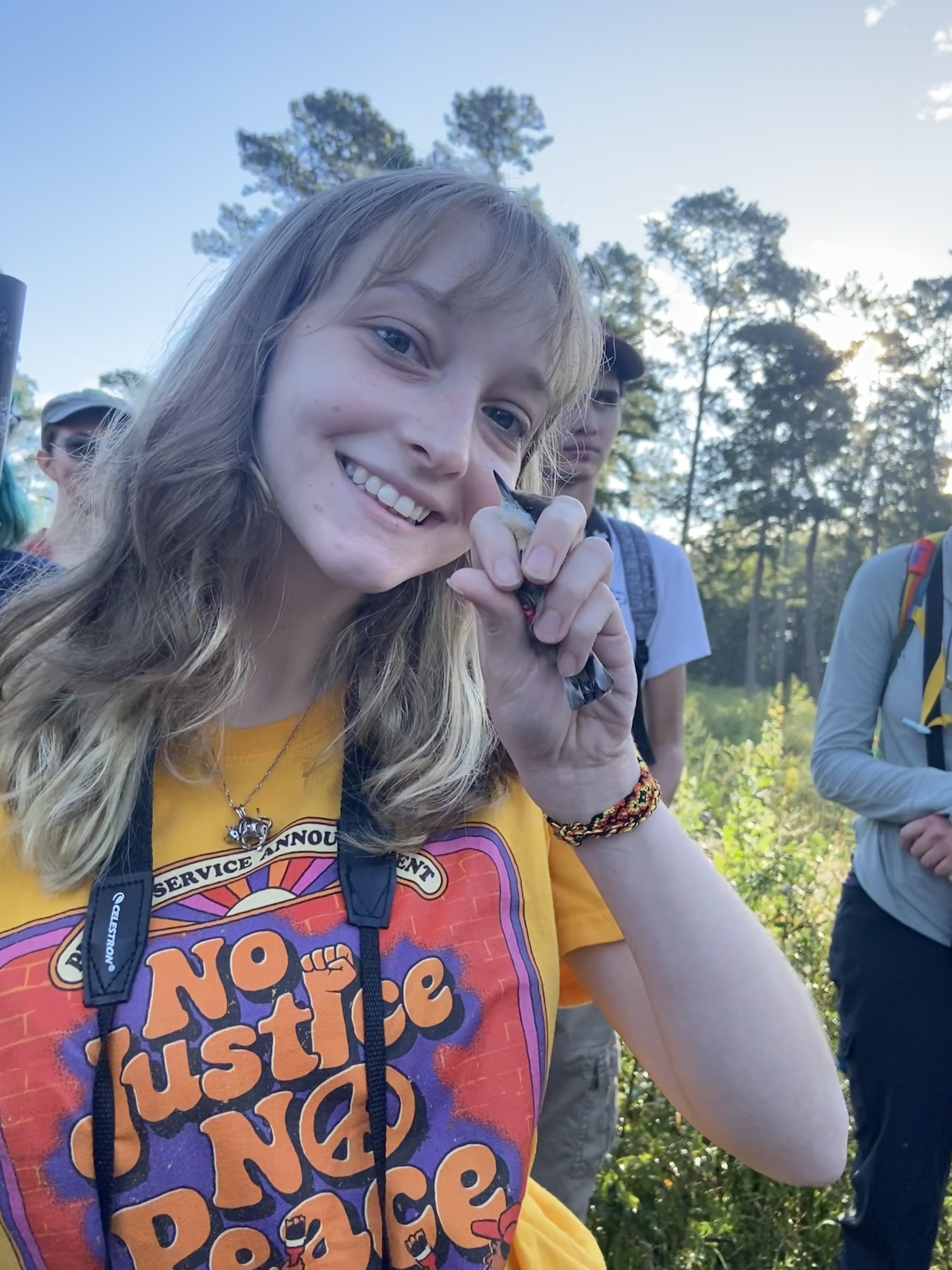 Kaya Simmons, field research with a bird, Sept 2025