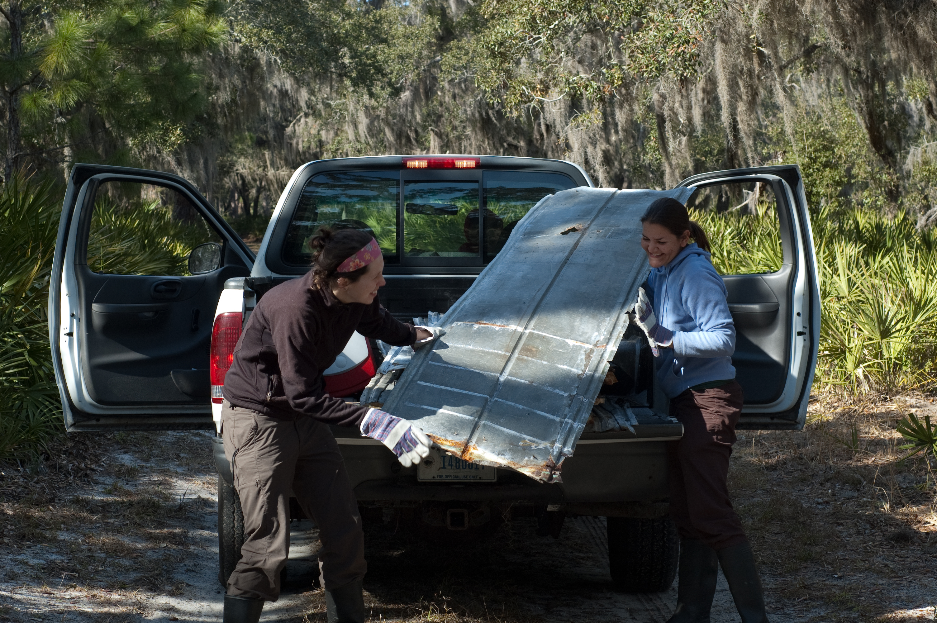 Lisa Barrow and Mallory Bedwell unloading field equipment from a truck