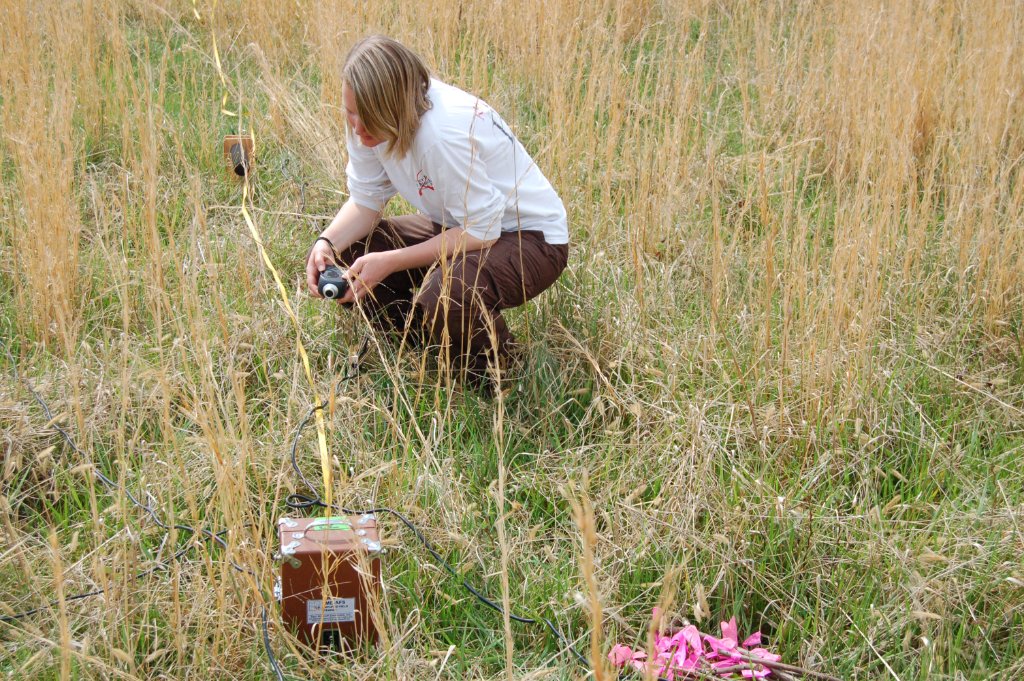 Setting up acoustic recording equipment at a pond edge at night