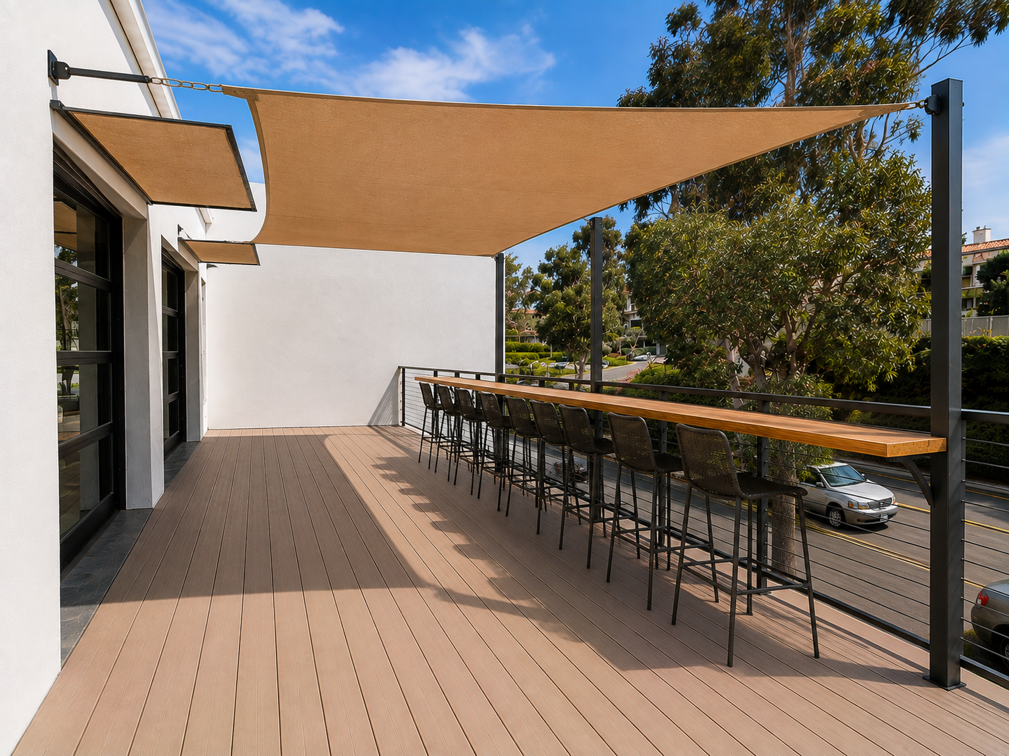 Back deck at The Visionary — wooden bar counter, high chairs, and tan awning