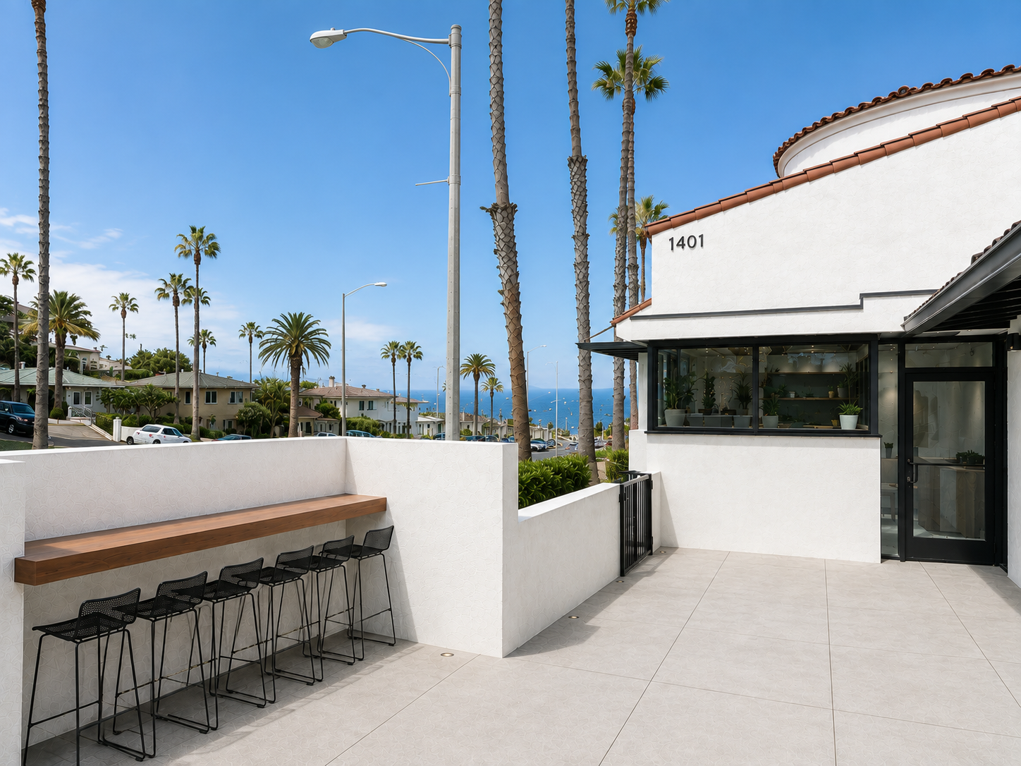Front work deck at The Visionary — wooden bar desk, high-top stools, and ocean view