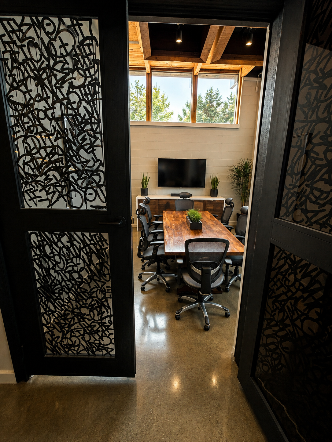 The famous board room in Dale Velzy's former office at The Visionary — live-edge table, ergonomic chairs, and clerestory windows