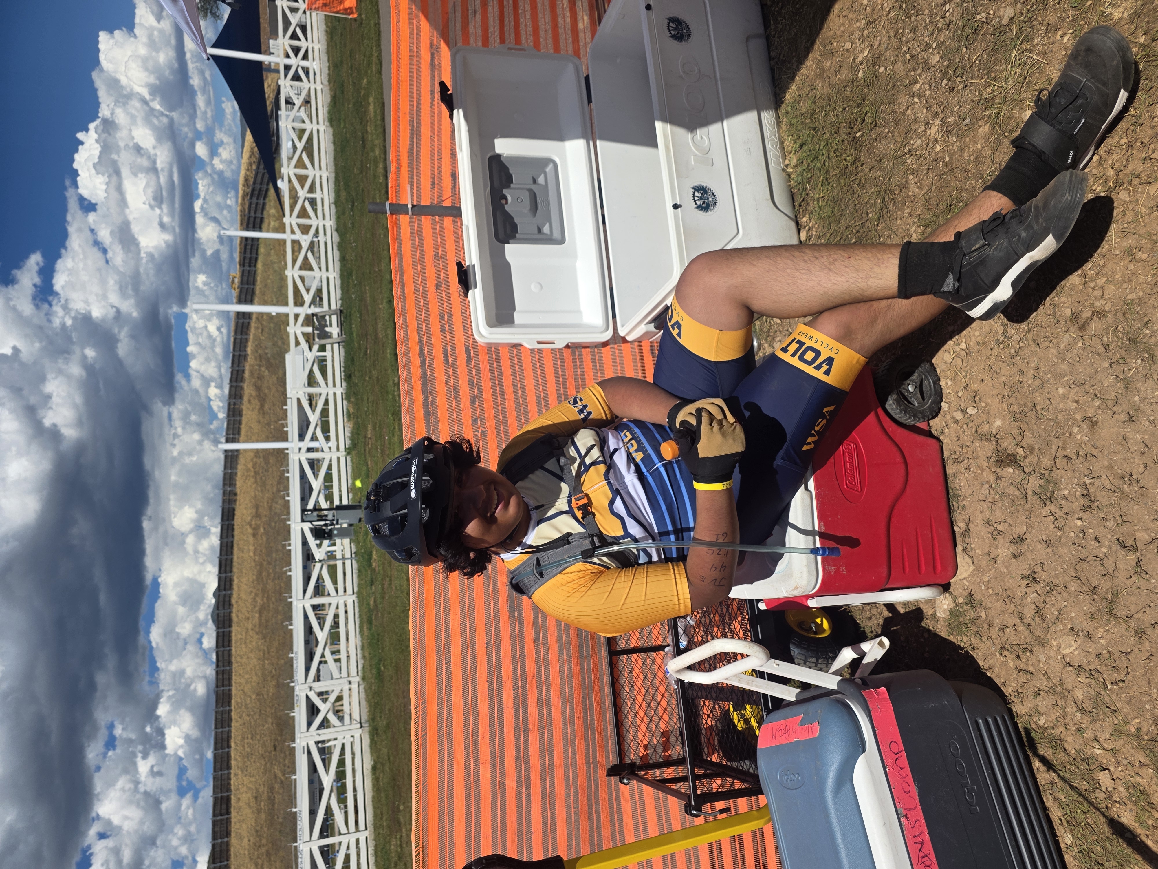 Rider resting on a red cooler at the race