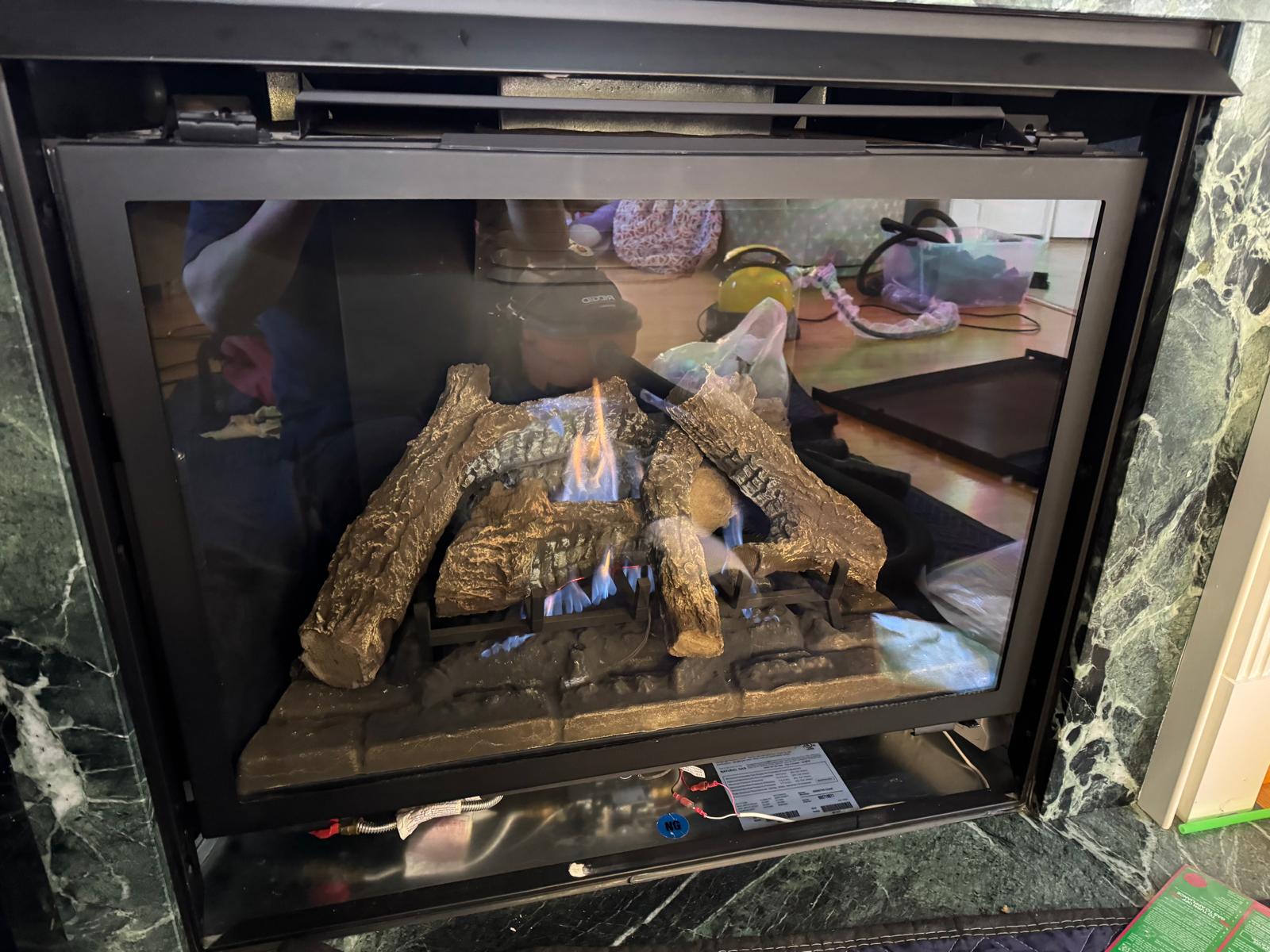 Gas fireplace after Capital Gas repair — clean glass, bright steady flame, fully operational