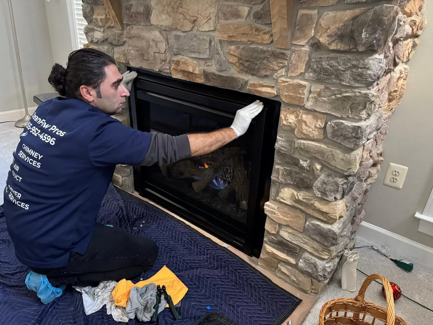Capital Gas Fireplace Repair technician adjusting a gas fireplace insert during an in-home service visit in Northern Virginia