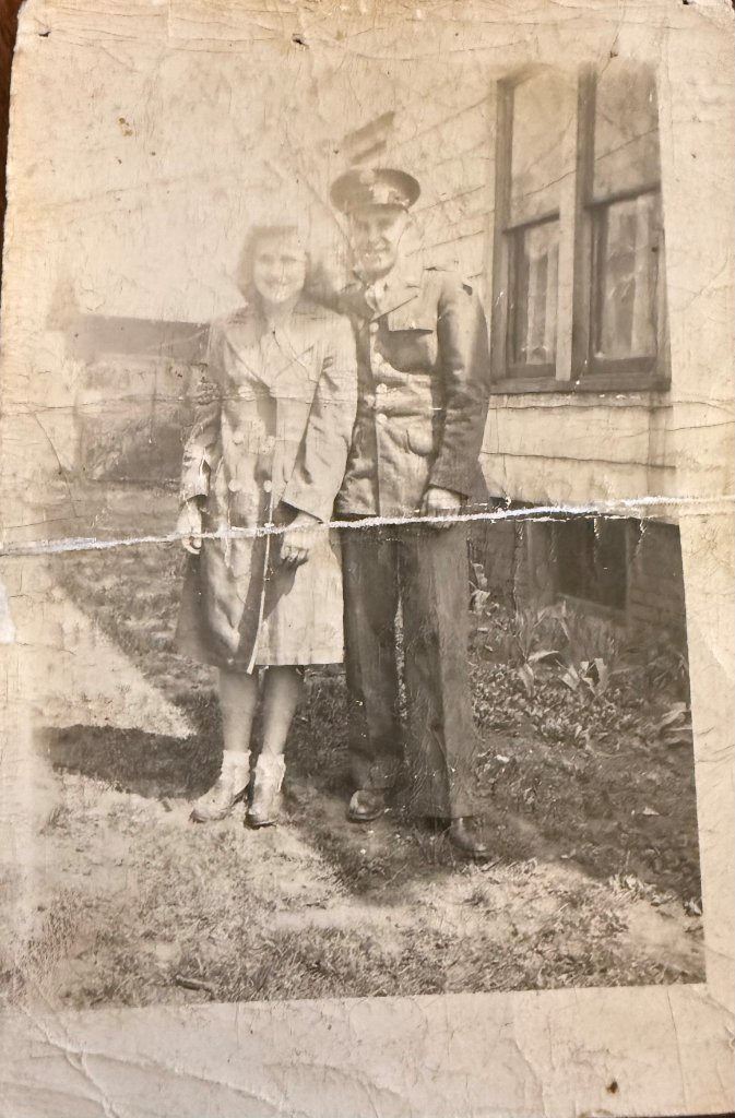 Elmer and June standing in front of a house