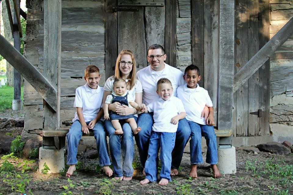 Trooper Ben with his family on a wooden porch