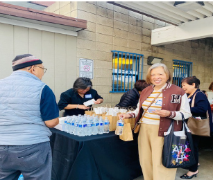 Retreat participants receiving breakfast brown bags and bottled water at the hospitality table