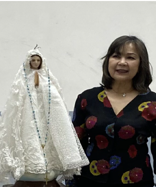 Emma Ronquillo, FFRGOC Director of Religious Enrichment, standing beside the Blessed Mother Statue