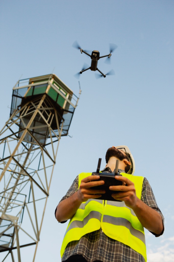 Airframe pilot inspecting a power transmission tower with a drone