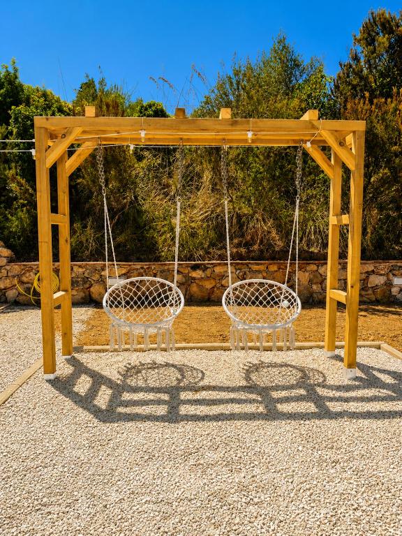 Pergolato con sedie sospese nel giardino di Reale Home