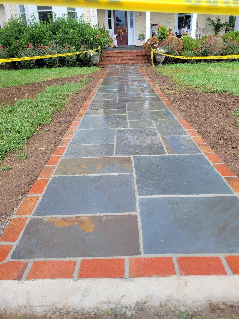 Flagstone walkway with brick border leading to a home