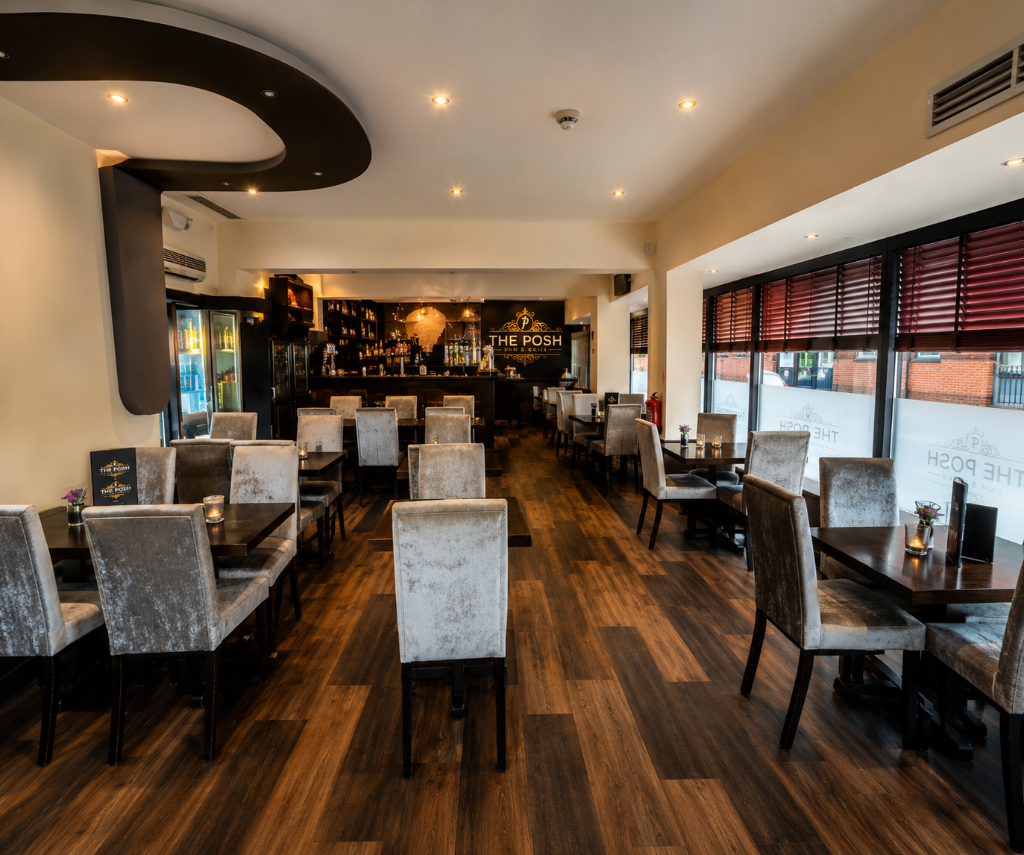 Inside The Posh Public House, dining tables with the bar in the background