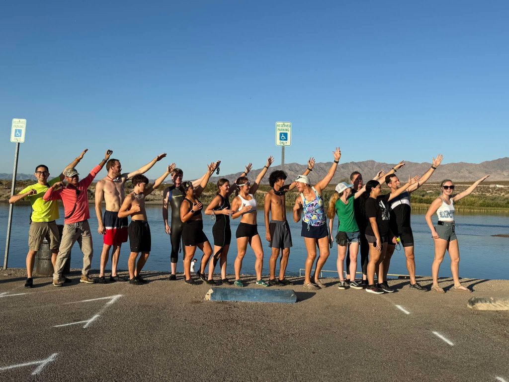 Desert Juggernauts athletes posing together by the river after a Bullhead City race