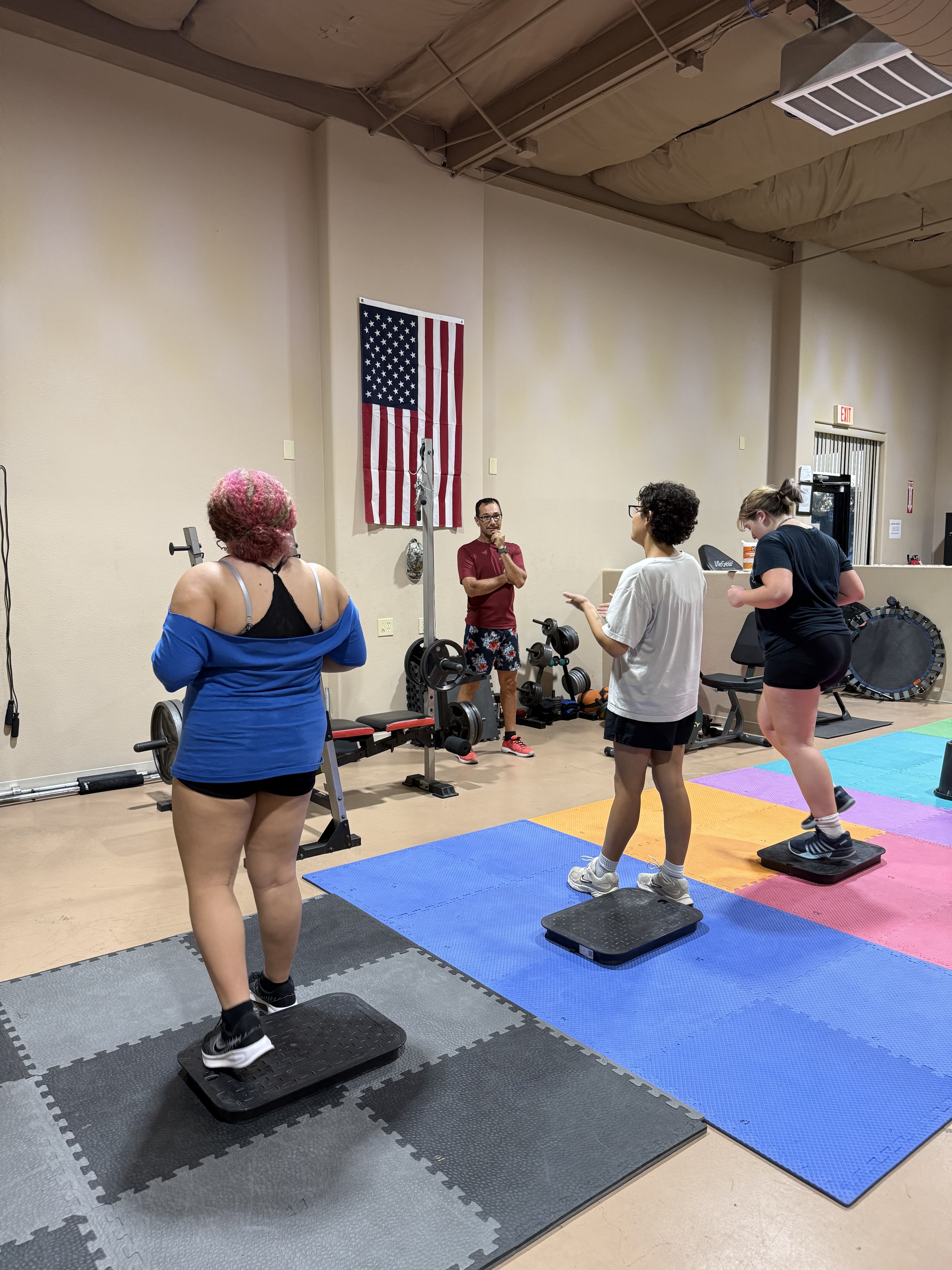 A coach guiding adults and young athletes through a session at the Juggernaut Training Facility