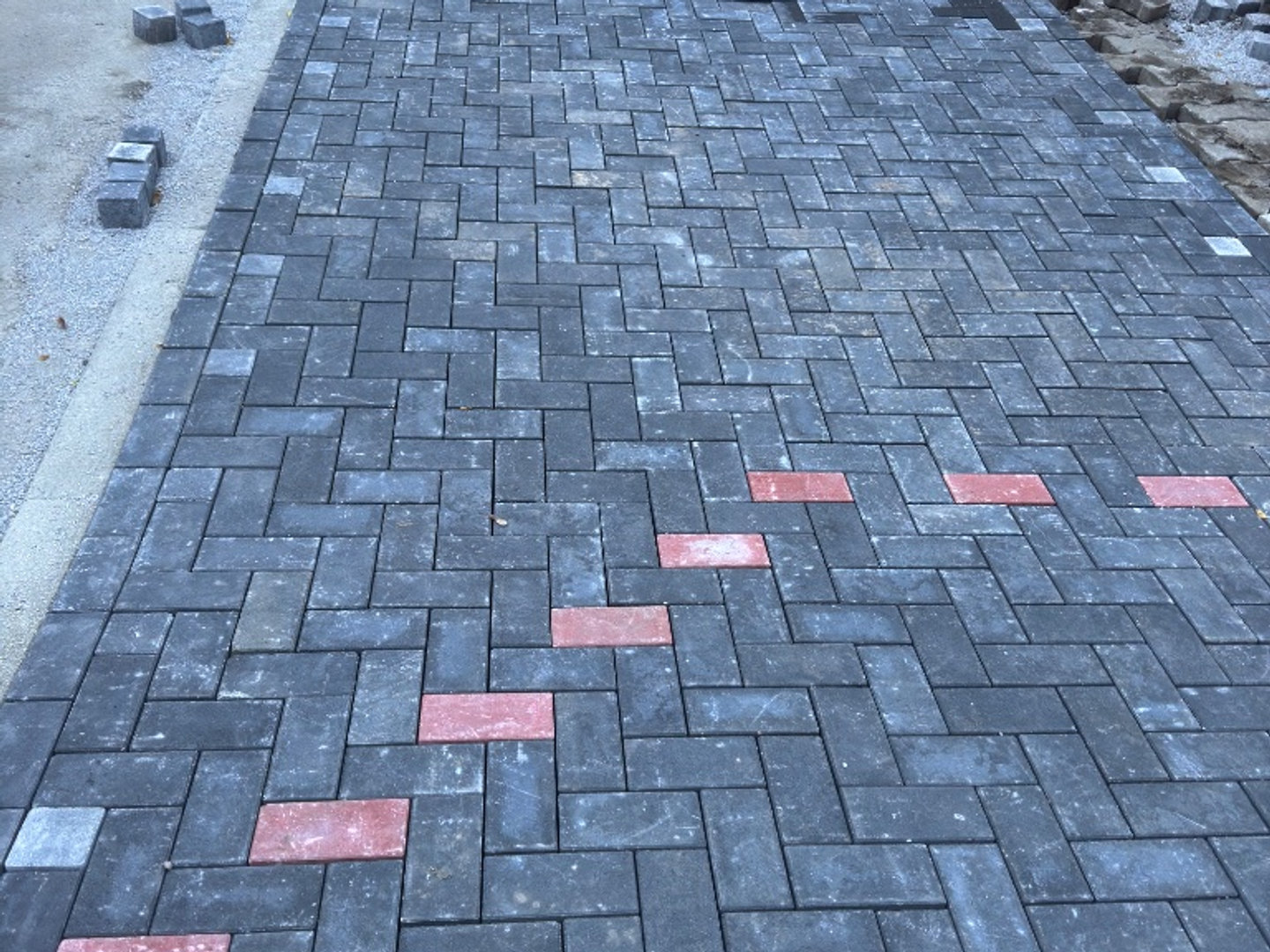 Herringbone-Pflaster – Rote Akzentlinie – IGA Garten- und Landschaftsbau