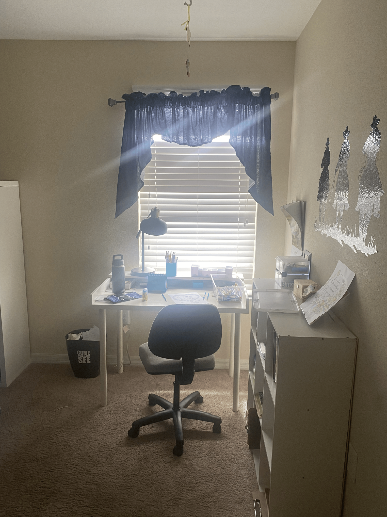 Home office with white desk, ergonomic chair, and silhouette wall art