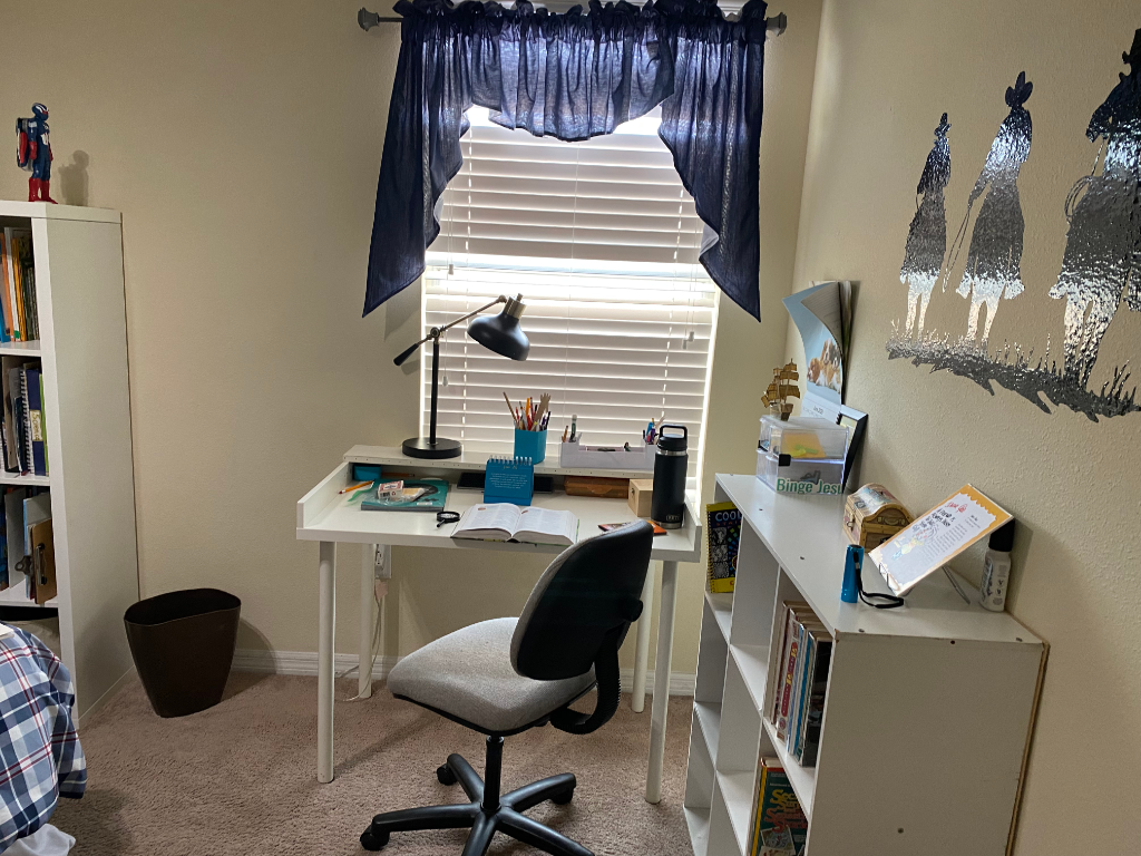 Student desk corner with bookcase, blue valance, and cowboy wall decal