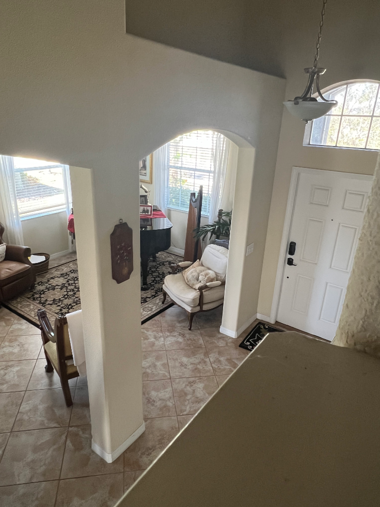 Foyer entry with arched doorways, soaring ceilings, and front door